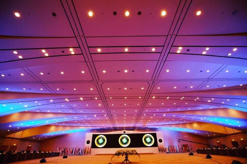IMCTC conference — assembly hall with flags, leadership and chiefs with IMCTC branding, modern auditorium
